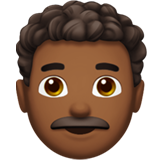 Cómo se ve el emoji Hombre: tono de piel oscuro medio y pelo rizado en Apple.