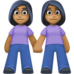 Cómo se ve el emoji Mujeres de la mano: tono de piel oscuro medio en Facebook.